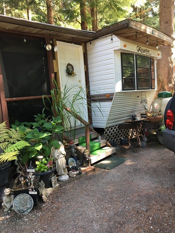 Camper surrounded by plants and decorations.
