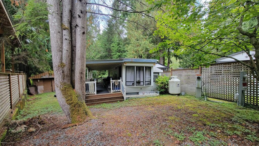 Cabin surrounded by trees and greenery.