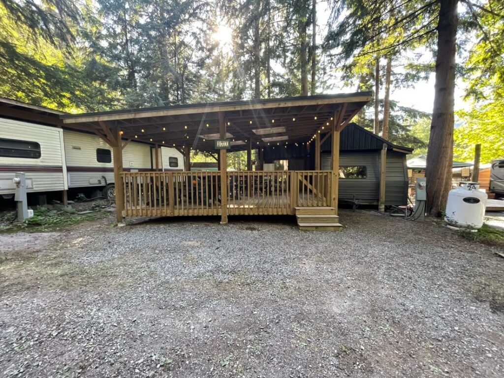Wooden deck with string lights in forest.